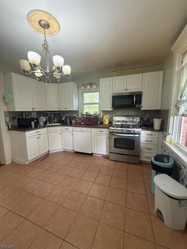 69 Lewis St, Perth Amboy City, NJ 08861 - kitchen with stainless steel appliances, tasteful backsplash, healthy amount of natural light, and a chandelier