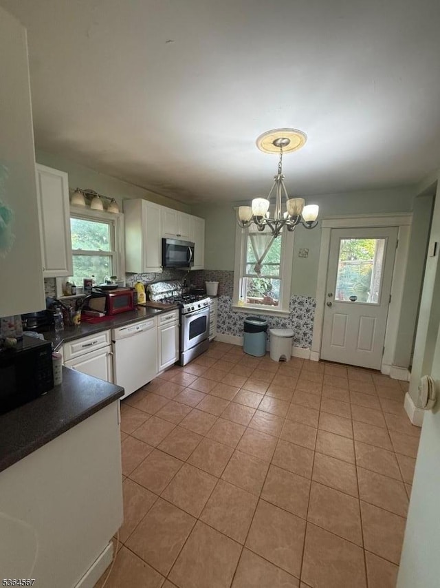 69 Lewis St, Perth Amboy City, NJ 08861 - kitchen featuring stainless steel range with gas stovetop, white dishwasher, healthy amount of natural light, and dark countertops