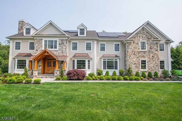 75 Keystone Ct, Bernards Twp, NJ 07920 - view of front of property with stone siding, roof mounted solar panels, a front yard, and a chimney