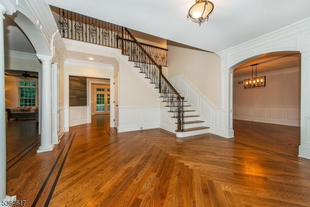 75 Keystone Ct, Bernards Twp, NJ 07920 - entrance foyer featuring ornate columns, arched walkways, ornamental molding, stairway, and wainscoting