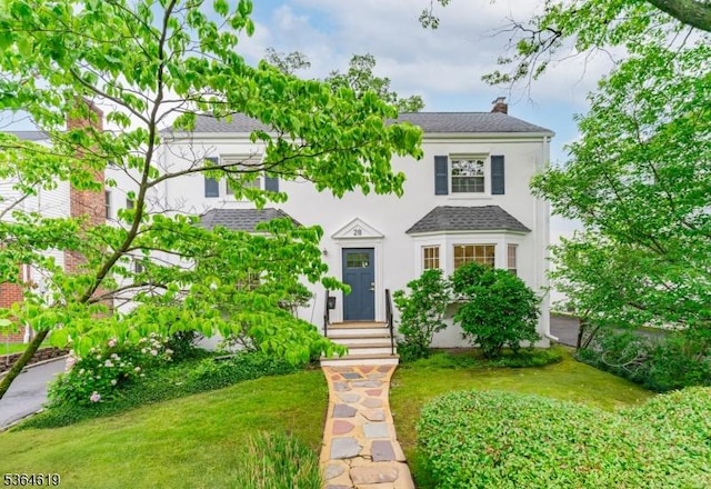 28-30 Reynolds Pl, Newark City, NJ 07106 - view of front of house with a chimney, stucco siding, roof with shingles, a front lawn, and entry steps