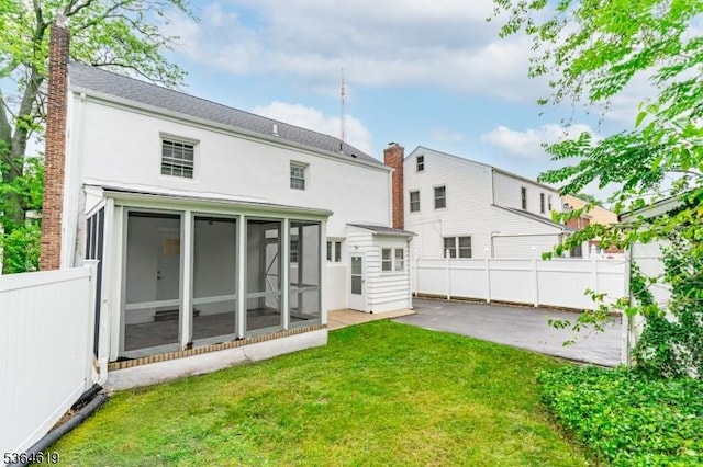28-30 Reynolds Pl, Newark City, NJ 07106 - rear view of property featuring a sunroom, a patio, a chimney, and stucco siding