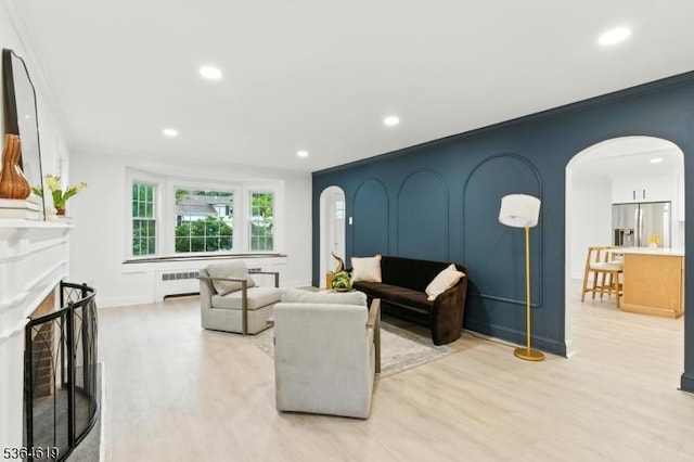 28-30 Reynolds Pl, Newark City, NJ 07106 - living room featuring arched walkways, radiator, light wood finished floors, recessed lighting, and ornamental molding