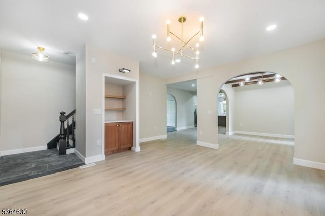 2 New Mashipacong Rd, Montague Twp, NJ 07827 - unfurnished living room featuring arched walkways, a chandelier, light wood finished floors, stairs, and recessed lighting