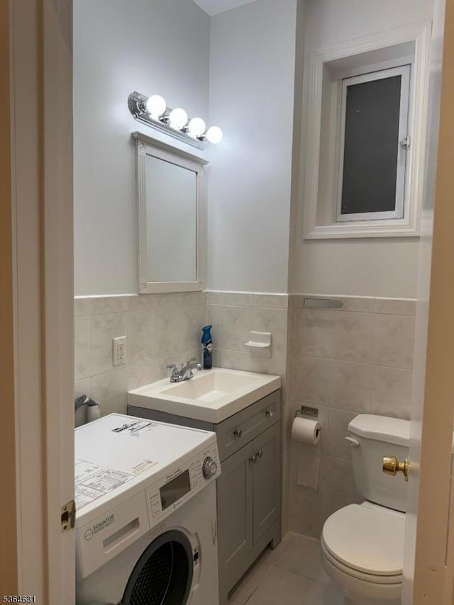 720 Boulevard, Weehawken Twp., NJ 07086 - half bathroom featuring washer / dryer, tile walls, vanity, tile patterned flooring, and a wainscoted wall