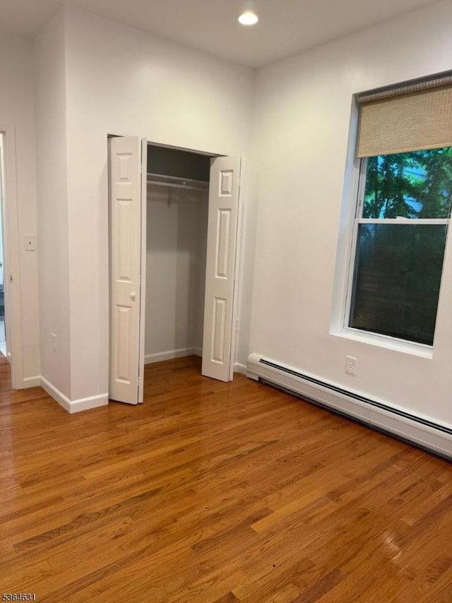 720 Boulevard, Weehawken Twp., NJ 07086 - unfurnished bedroom with a baseboard radiator, wood finished floors, a closet, and recessed lighting