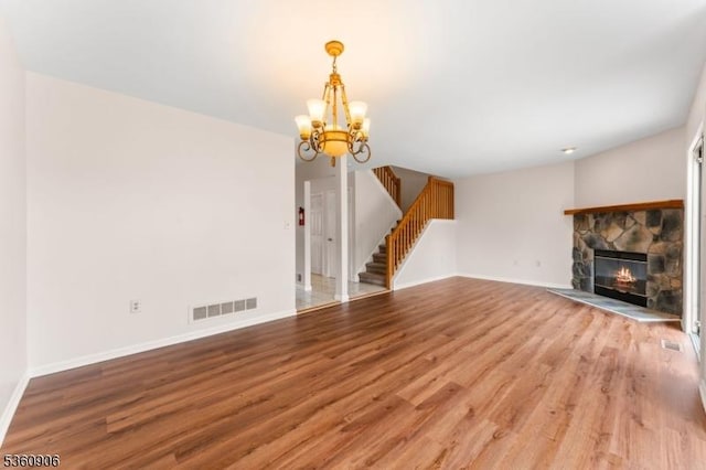 26 Allison Ct, South Brunswick Twp, NJ 08852 - unfurnished living room featuring light wood-style flooring, stairs, a chandelier, and a fireplace