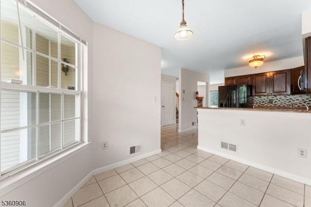 26 Allison Ct, South Brunswick Twp, NJ 08852 - kitchen featuring black fridge with ice dispenser, decorative backsplash, dark brown cabinetry, hanging light fixtures, and stainless steel microwave