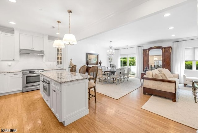 19 Whitney Farm Pl, Morris Twp, NJ 07960 - kitchen featuring appliances with stainless steel finishes, under cabinet range hood, a chandelier, white cabinetry, and a breakfast bar