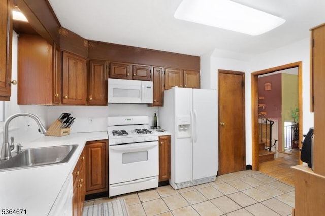 608 Faitoute Ave, Roselle Park Boro, NJ 07204 - kitchen featuring white appliances, light countertops, light tile patterned flooring, and brown cabinetry