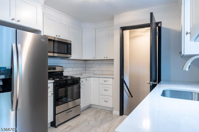 123 Baier Ave, Franklin Twp, NJ 08873 - kitchen with stainless steel appliances, light countertops, white cabinets, decorative backsplash, and light marble finish floors