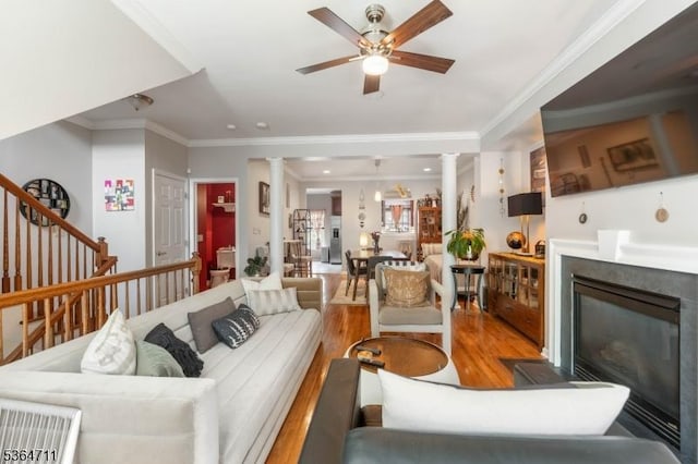 746 Green Ln, Union Twp, NJ 07083 - living room featuring decorative columns, light wood-style floors, crown molding, a glass covered fireplace, and a ceiling fan