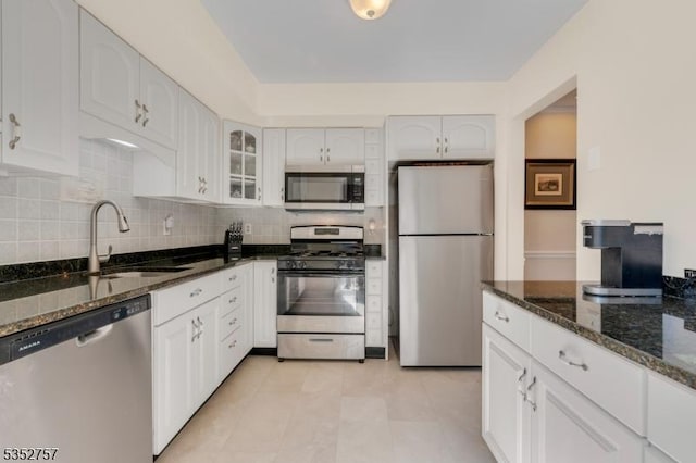 147 Nottingham Sq, Washington Twp, NJ 07840 - kitchen featuring appliances with stainless steel finishes, dark stone counters, glass insert cabinets, white cabinets, and decorative backsplash