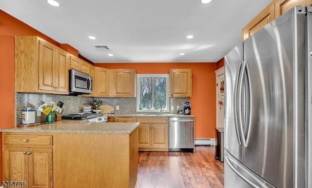 15 Parker St, East Brunswick Twp, NJ 08816 - kitchen with stainless steel appliances, wood finished floors, tasteful backsplash, a peninsula, and recessed lighting