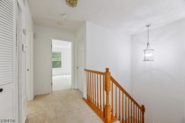 44 Treat Ln, East Brunswick Twp, NJ 08816 - corridor featuring an upstairs landing, light colored carpet, a textured ceiling, and a chandelier
