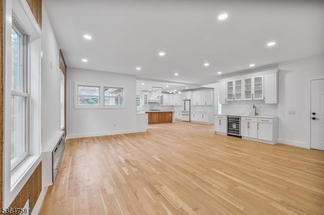 332 Springfield Ave, Westfield Town, NJ 07090 - unfurnished living room with wine cooler, light wood-type flooring, recessed lighting, and bar area