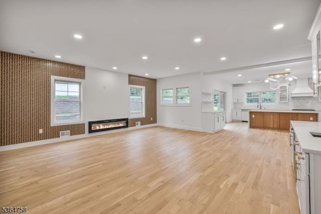 332 Springfield Ave, Westfield Town, NJ 07090 - unfurnished living room featuring a glass covered fireplace, light wood-style floors, plenty of natural light, and recessed lighting