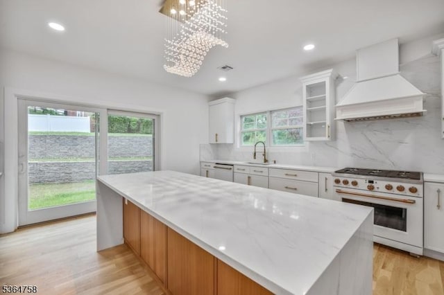 332 Springfield Ave, Westfield Town, NJ 07090 - kitchen featuring high end white range oven, custom range hood, tasteful backsplash, white cabinetry, and light wood-style floors