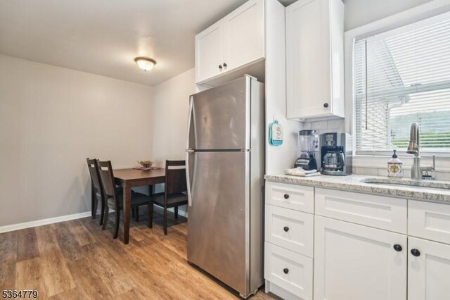 458 Midland Ave, Pompton Lakes Boro, NJ 07442 - kitchen with freestanding refrigerator, white cabinetry, light wood-style floors, and light stone countertops