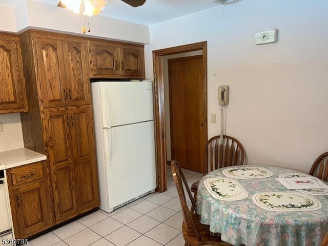 797 Chestnut St, Union Twp, NJ 07083 - kitchen featuring freestanding refrigerator, brown cabinets, a ceiling fan, light tile patterned floors, and light countertops