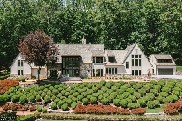 171 Campbell Rd, Bernardsville Boro, NJ 07924 - rear view of property featuring stone siding, a chimney, and a garage