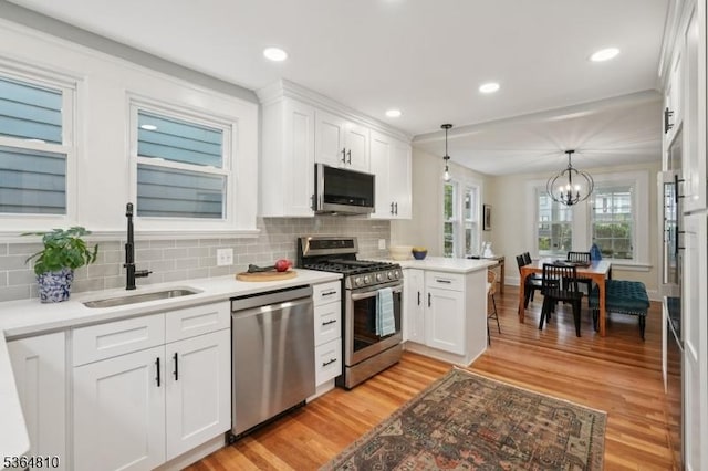 26 Saint Lawrence Ave, Maplewood Twp, NJ 07040 - kitchen featuring stainless steel appliances, light wood-style flooring, white cabinets, decorative backsplash, and recessed lighting