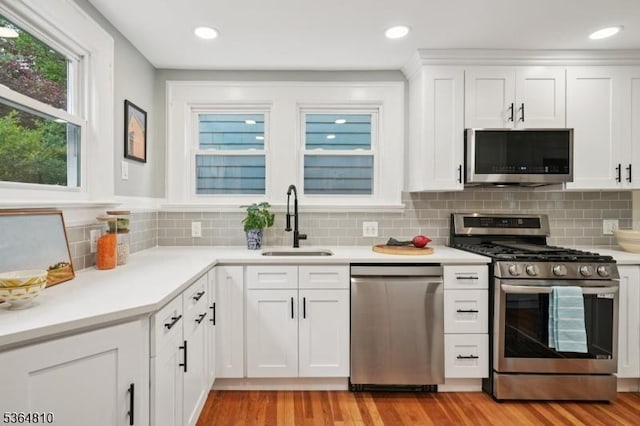 26 Saint Lawrence Ave, Maplewood Twp, NJ 07040 - kitchen with appliances with stainless steel finishes, light wood finished floors, white cabinetry, tasteful backsplash, and recessed lighting