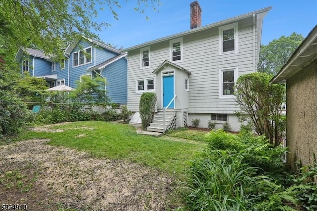 26 Saint Lawrence Ave, Maplewood Twp, NJ 07040 - rear view of property with entry steps, a chimney, and a lawn