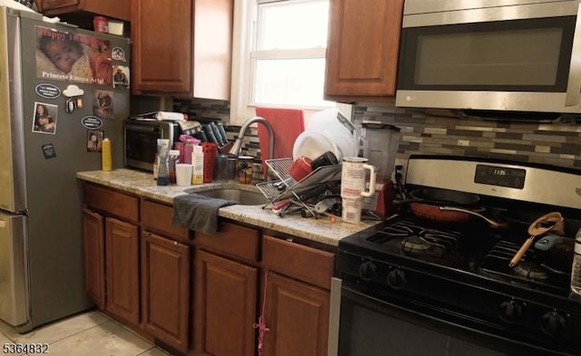 1371 Clinton Ave, Irvington Twp, NJ 07111 - kitchen featuring stainless steel appliances, backsplash, light tile patterned floors, and brown cabinetry