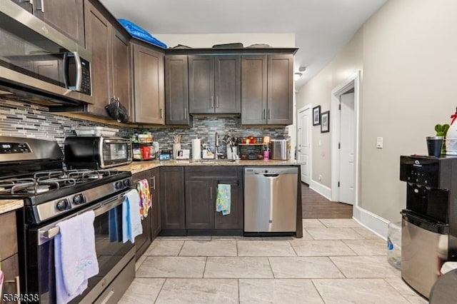 29 Pitt St, Bloomfield Twp, NJ 07003 - kitchen with stainless steel appliances, tasteful backsplash, dark brown cabinetry, and light stone counters