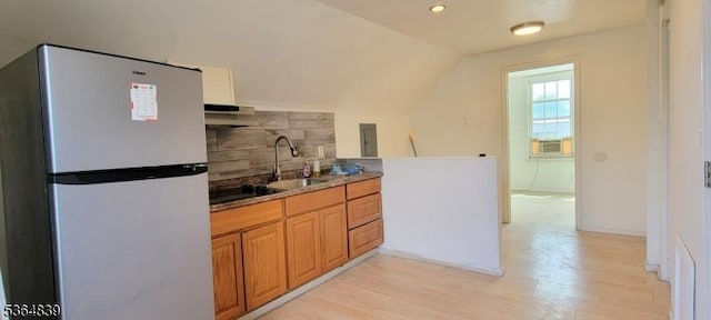 209 Sylvan Ave, Newark City, NJ 07104 - kitchen with freestanding refrigerator, decorative backsplash, light wood-type flooring, under cabinet range hood, and vaulted ceiling