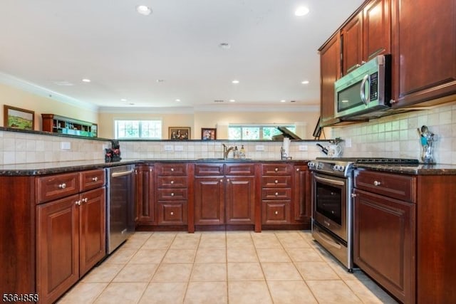 1409 Warrens Way Unit 1409, Wanaque Boro, NJ 07465 - kitchen with appliances with stainless steel finishes, backsplash, dark stone counters, ornamental molding, and reddish brown cabinets