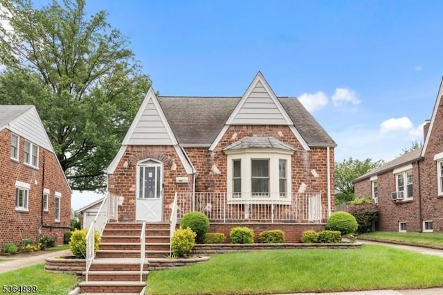 1221 Kelly St, Union Twp, NJ 07083 - tudor home featuring a front lawn, a shingled roof, and brick siding