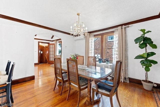 1221 Kelly St, Union Twp, NJ 07083 - dining space with arched walkways, light wood finished floors, a chandelier, and crown molding