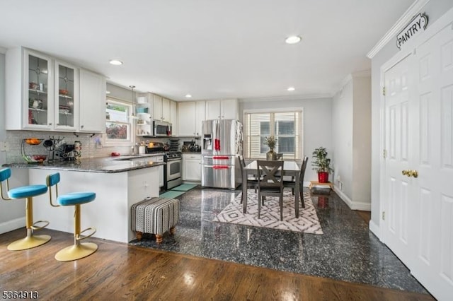 286 Meadow Rd Unit Rt17, Serv Rutherford Boro, NJ 07070 - kitchen featuring stainless steel appliances, ornamental molding, backsplash, glass insert cabinets, and a peninsula