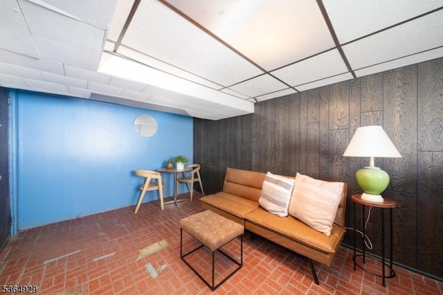 317 Stevens Ave, Jersey City, NJ 07305 - living area featuring brick patterned floors, wood walls, and a drop ceiling