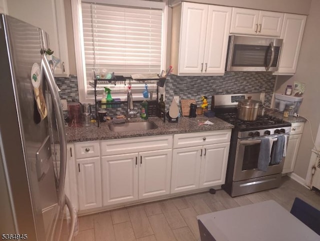 341 N Grove St, East Orange City, NJ 07017 - kitchen with stainless steel appliances, backsplash, white cabinetry, and light wood-style flooring