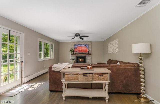 25 Old Turnpike Rd, Washington Twp, NJ 07865 - living room with baseboard heating, wood finished floors, a brick fireplace, ceiling fan, and ornamental molding
