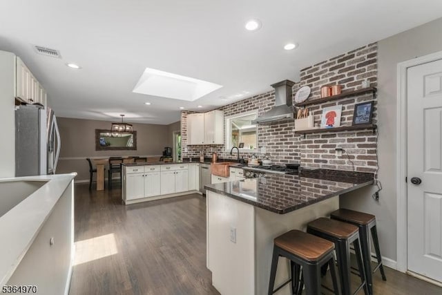 25 Old Turnpike Rd, Washington Twp, NJ 07865 - kitchen with a peninsula, wall chimney range hood, stainless steel appliances, a skylight, and dark wood-type flooring