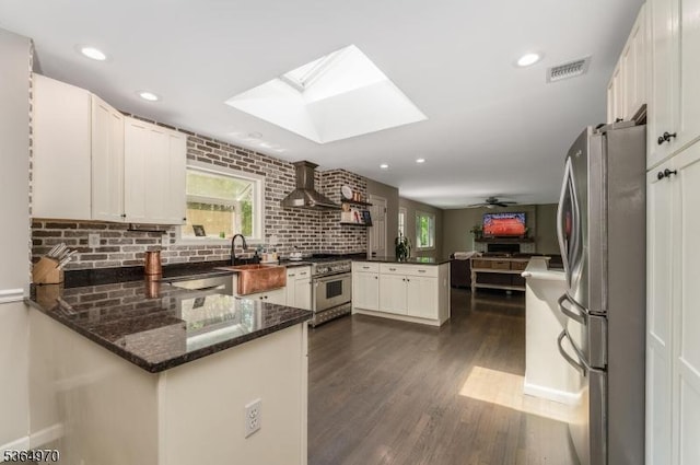 25 Old Turnpike Rd, Washington Twp, NJ 07865 - kitchen featuring appliances with stainless steel finishes, a peninsula, wall chimney range hood, a skylight, and dark wood-style floors