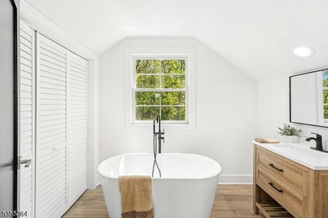 944 Orange Ave, Cranford Twp, NJ 07016 - full bathroom featuring a closet, vanity, a soaking tub, and vaulted ceiling