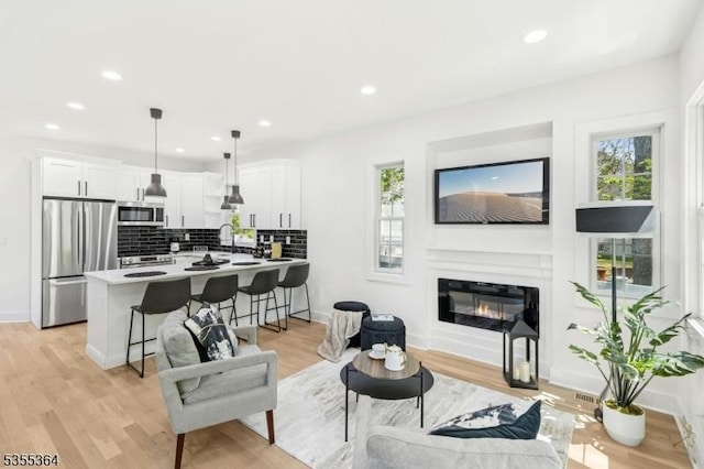 944 Orange Ave, Cranford Twp, NJ 07016 - living room with light wood-type flooring, recessed lighting, and a glass covered fireplace