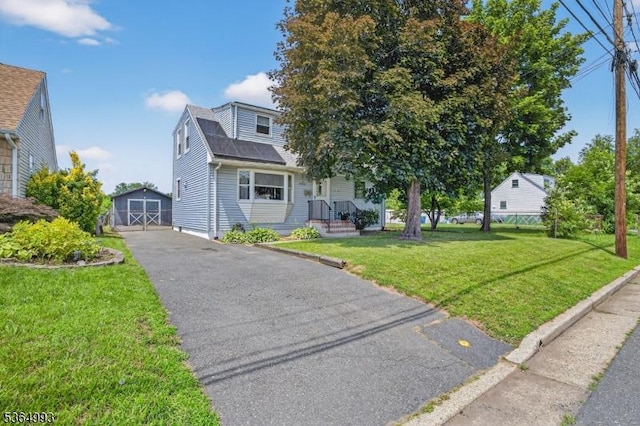 1033 Huff Ave, Manville Boro, NJ 08835 - view of front facade featuring asphalt driveway, a front lawn, a storage shed, and a garage