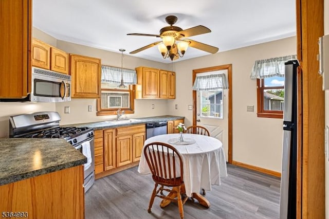 1033 Huff Ave, Manville Boro, NJ 08835 - kitchen with stainless steel appliances, light wood-style floors, ceiling fan, dark countertops, and hanging light fixtures