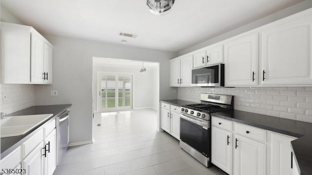 122 Madison St, South Bound Brook Boro, NJ 08880 - kitchen with appliances with stainless steel finishes, dark countertops, backsplash, and white cabinets