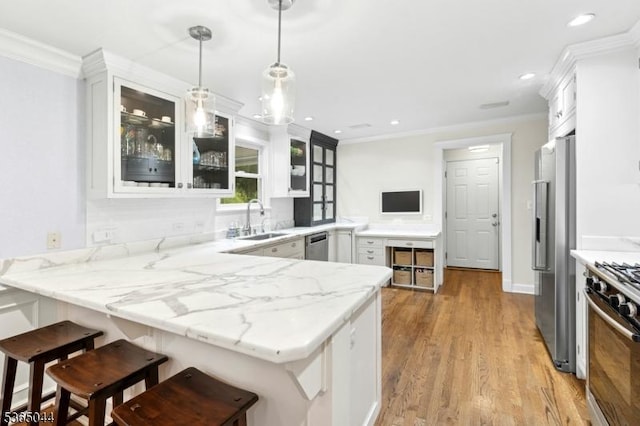 849 Bradford Ave, Westfield Town, NJ 07090 - kitchen with stainless steel appliances, a peninsula, light wood finished floors, white cabinets, and ornamental molding