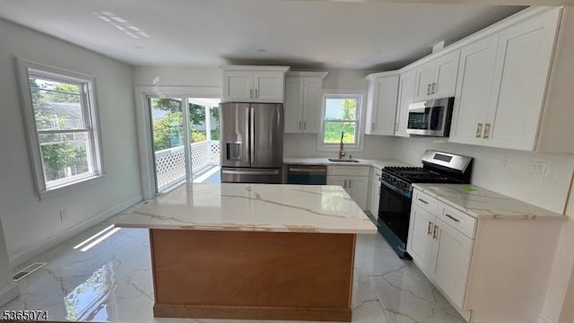 882 Lafayette Ave, Hawthorne Boro, NJ 07506 - kitchen with appliances with stainless steel finishes, light marble finish floors, a center island, and white cabinets