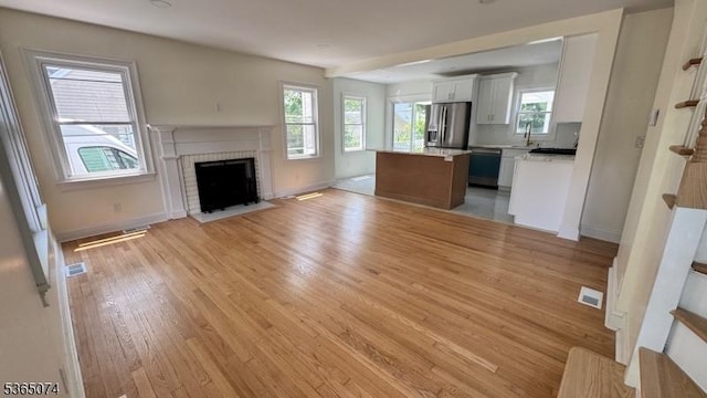 882 Lafayette Ave, Hawthorne Boro, NJ 07506 - unfurnished living room with light wood-type flooring and a brick fireplace