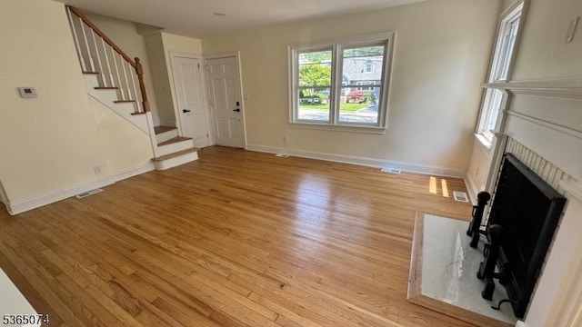 882 Lafayette Ave, Hawthorne Boro, NJ 07506 - unfurnished living room with light wood-style floors, stairway, and a fireplace with flush hearth