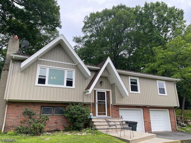 126 Hilltop Trl, Sparta Twp, NJ 07871 - bi-level home featuring brick siding, an attached garage, board and batten siding, a chimney, and driveway